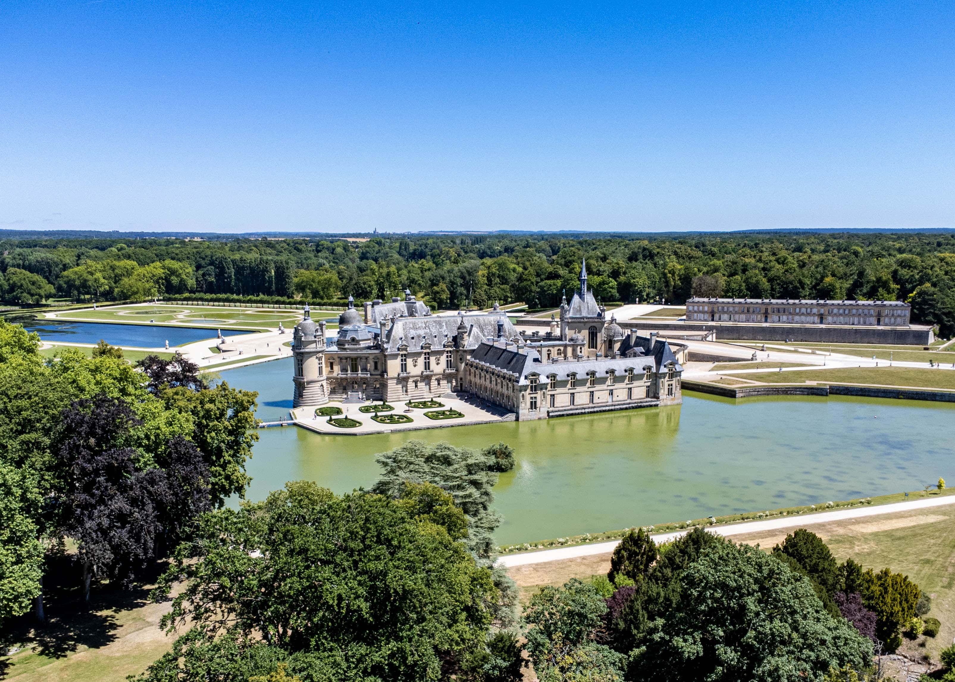 Photo du château de Chantilly entouré d'eau.